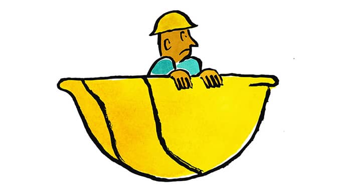 A worker sitting in a large hard hat